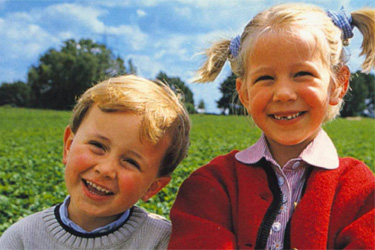 Kinder vor einem Erdbeerfeld